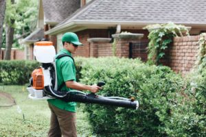 A Mosquito Joe service technician applies outdoor treatments to a front lawn in Texas.